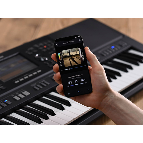 Yamaha Arrange Workstation PSR-SX920 and a hand holding a smartphone with a music player screen