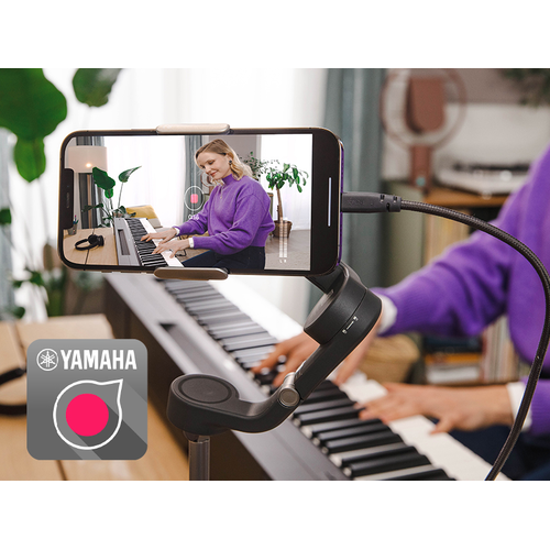A view of the Yamaha Rec'n'Share app icon and a person taking a smartphone video of them playing