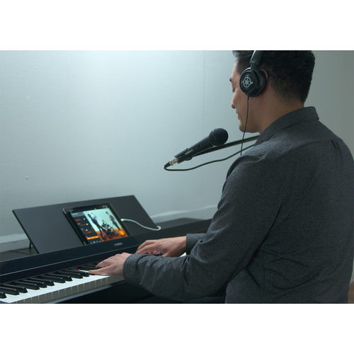 A person singing and playing with headphones and a microphone 